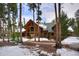 Beautiful exterior of log cabin home surrounded by mature trees and snow-covered landscape at 47 Forest Cir, Breckenridge, CO 80424