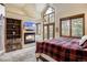 Comfortable bedroom with a fireplace, large windows showcasing nature, and rustic furnishings for a serene retreat at 47 Forest Cir, Breckenridge, CO 80424