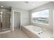 Bright bathroom featuring a shower, tub, and window with a scenic view at 47032 Frasier Fir Cir, Parker, CO 80138