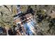 Aerial view of a home nestled among trees with multiple vehicles in the driveway at 11953 Us Highway 285, Conifer, CO 80433