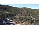 Wide aerial shot of a home surrounded by vast, dense forest land in a mountain setting at 11953 Us Highway 285, Conifer, CO 80433