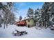 House exterior with a deck, surrounded by snow-covered trees at 11953 Us Highway 285, Conifer, CO 80433
