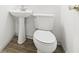Simple half-bath with pedestal sink and modern toilet on wood-look floors at 677 Vrain St # 15, Denver, CO 80204