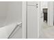 Well-lit hallway with access to staircase and bedroom, featuring white walls and neutral carpet at 677 Vrain St # 15, Denver, CO 80204