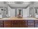 Bathroom featuring double sinks, a wooden vanity, and large mirrors at 10683 Amesbury Way, Highlands Ranch, CO 80126
