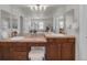 Bathroom featuring double sinks with wood cabinets, tile countertops and floors, and decorative lighting at 10683 Amesbury Way, Highlands Ranch, CO 80126