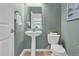 A well-lit powder room with a pedestal sink and toilet, designed with style and functionality at 10683 Amesbury Way, Highlands Ranch, CO 80126