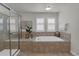 Relaxing bathroom featuring a glass shower, a soaking tub, and shuttered windows at 10683 Amesbury Way, Highlands Ranch, CO 80126