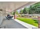 The home's covered patio features a dining area with brick columns and a manicured lawn at 10683 Amesbury Way, Highlands Ranch, CO 80126