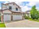 Charming two-story home featuring a three car garage and a well-maintained lawn, showcasing curb appeal at 10683 Amesbury Way, Highlands Ranch, CO 80126