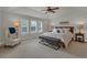 Bright main bedroom with tray ceiling, neutral colors, large windows, and comfortable seating at 10683 Amesbury Way, Highlands Ranch, CO 80126