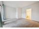 Bright bedroom with neutral carpet, white walls, and a doorway that leads into an en-suite bathroom at 2824 W Centennial Dr # L, Littleton, CO 80123