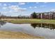 Scenic community view showcasing the pond and the nearby complex with lush greenery at 2824 W Centennial Dr # L, Littleton, CO 80123