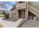 Charming condo entrance with stone accents, exterior staircase, and manicured landscaping at 2824 W Centennial Dr # L, Littleton, CO 80123