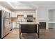 Bright kitchen featuring a kitchen island, stainless appliances, and wood floors at 2824 W Centennial Dr # L, Littleton, CO 80123