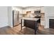 Bright kitchen featuring a kitchen island, stainless appliances, and wood floors at 2824 W Centennial Dr # L, Littleton, CO 80123
