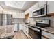 Well lit kitchen with modern appliances, stainless steel refrigerator, granite countertops and tile backsplash at 2824 W Centennial Dr # L, Littleton, CO 80123