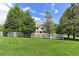 Beautiful home featuring a large backyard with mature trees and a charming white fence, perfect for outdoor enjoyment at 7858 Oban Ct, Lone Tree, CO 80124
