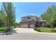 Charming two-story home featuring a brick facade, three-car garage, and lush landscaping at 7858 Oban Ct, Lone Tree, CO 80124
