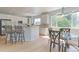 Bright kitchen featuring white cabinetry, a breakfast bar, and an adjacent eat-in dining space at 7858 Oban Ct, Lone Tree, CO 80124