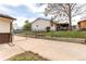 Backyard with a chain-link fence surrounding a grassy area with a shed and carport visible at 261 Linda Ln, Denver, CO 80221