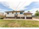 Exterior of the home with a large backyard, featuring a walk-out door and a fenced-in area at 261 Linda Ln, Denver, CO 80221