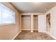 Bedroom featuring a large window, neutral walls, and a built-in closet system for ample storage at 261 Linda Ln, Denver, CO 80221