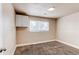 Bright bedroom with a window, neutral walls, carpet, and overhead storage at 261 Linda Ln, Denver, CO 80221