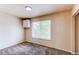 Bedroom with neutral paint, plush carpet, and bright natural light from the window at 261 Linda Ln, Denver, CO 80221