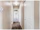 Hallway featuring neutral paint, carpet flooring, storage, and an open doorway at 261 Linda Ln, Denver, CO 80221
