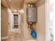 Hallway with a tankless water heater; tiled floors and entry to another room add detail at 261 Linda Ln, Denver, CO 80221