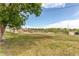 Grassy lot with views of distant buildings and power lines, showcasing the spaciousness at 261 Linda Ln, Denver, CO 80221