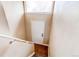 Stairway with tiled landing, carpeted stairs, leading to a white entry door at 261 Linda Ln, Denver, CO 80221