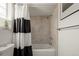 Bright bathroom featuring a shower-tub combo with neutral colored tiling at 4713 Perth St, Denver, CO 80249