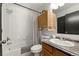Bathroom with tiled shower and tub, granite vanity and stylish wood cabinet at 4713 Perth St, Denver, CO 80249