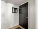 Hallway with dark door, hooks and mirror gives easy access to the home at 4713 Perth St, Denver, CO 80249