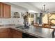 Kitchen island sink with breakfast bar adjoins dining area, cabinets, and tile floors at 4713 Perth St, Denver, CO 80249