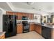 Kitchen includes tan cabinets, black appliances, granite countertops, and opens to dining area at 4713 Perth St, Denver, CO 80249
