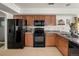 Efficient kitchen layout with ample cabinet space, black appliances and tile flooring at 4713 Perth St, Denver, CO 80249