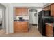 Kitchen area with tan cabinets, stainless refrigerator, leading into an adjacent bedroom at 4713 Perth St, Denver, CO 80249