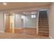 Spacious basement area featuring hardwood flooring and carpet, stairs, and a charming barn door at 1035 Quartz St, Golden, CO 80401