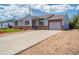 Single-story home boasts stone accents, red-framed windows, and a convenient two-car garage at 1035 Quartz St, Golden, CO 80401