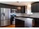 Modern kitchen with stainless steel appliances, granite countertops, and dark wood cabinetry at 1035 Quartz St, Golden, CO 80401