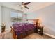 Bedroom with ceiling fan and window with blinds, featuring neutral carpet and wood bed frame at 9019 E Panorama Cir # D207, Englewood, CO 80112