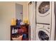 A laundry area featuring a stacked washer/dryer, shelves, and storage space at 9019 E Panorama Cir # D207, Englewood, CO 80112