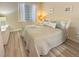 Bright bedroom featuring a queen bed with decorative pillows and light wood-look flooring at 9390 W Chatfield Pl # 103, Littleton, CO 80128