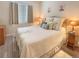 Cozy bedroom with a queen bed, decorative pillows and light wood-look flooring at 9390 W Chatfield Pl # 103, Littleton, CO 80128