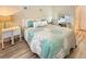 Comfortable bedroom with a vanity, queen bed with decorative pillows and light wood-look flooring at 9390 W Chatfield Pl # 103, Littleton, CO 80128