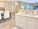 Well-lit kitchen with white cabinets, and an open view to the dining area at 9390 W Chatfield Pl # 103, Littleton, CO 80128