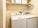 Efficient laundry room featuring a washer, dryer, and storage shelf at 9390 W Chatfield Pl # 103, Littleton, CO 80128